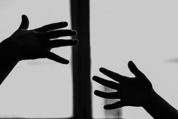 Silhouette of two hands reaching out toward each other against a light background, symbolizing connection and longing.