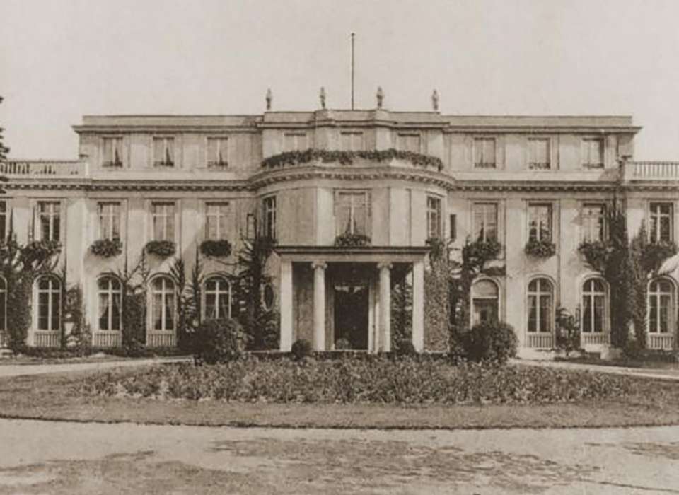 Historic villa exterior in Berlin, surrounded by a manicured garden, used for significant meetings during the Nazi regime.